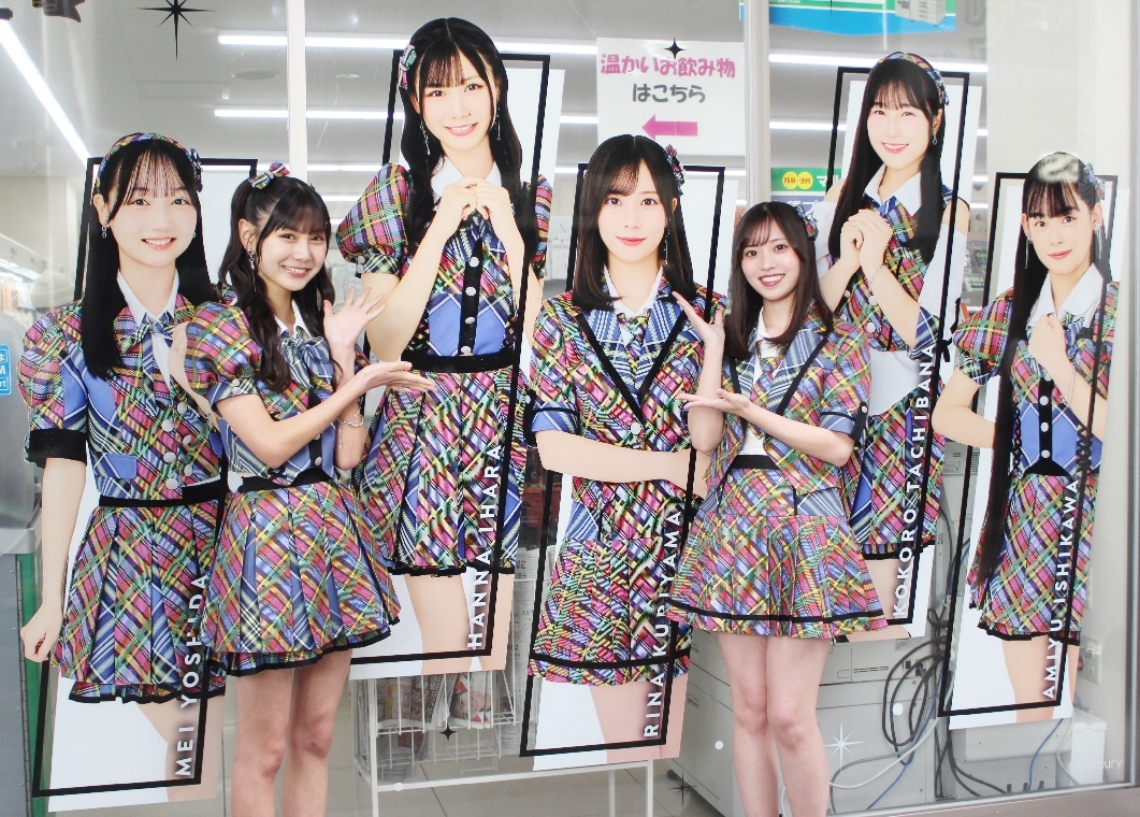 セントポルタ中央町にある大分中央町一丁目店でラッピングされた店舗をアピールする県出身の猪原絆愛（左）と栗山梨奈＝大分市