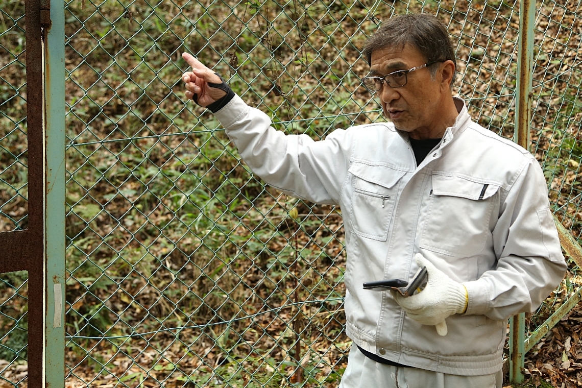 イスラム土葬墓地計画地近くの山林で、小内原集落の水源地について説明する渡辺雄爾さん＝１１月中旬、日出町