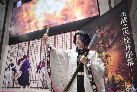 「鬼滅の刃」が上映される映画館で記念撮影をするコスプレ姿の人＝１１月、北京（共同）