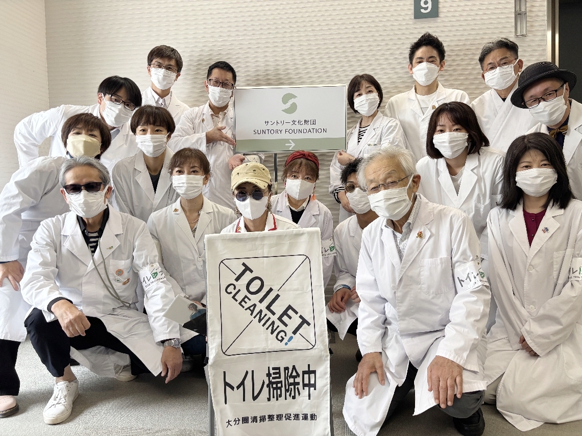 サントリー文化財団の職員と真面目な表情で記念撮影＝大阪市のサントリー文化財団