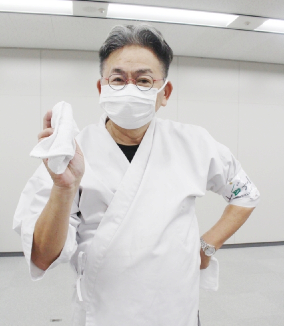 板前の白衣をまとった児玉憲明さん。「間違って持ってきてしまった」と言い張る