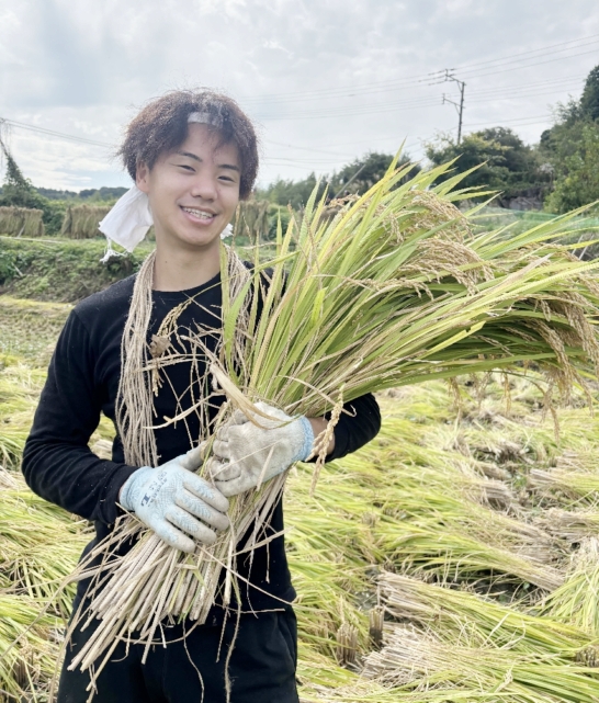初の稲刈りで満面の笑みを浮かべる船口凌さん＝１０月１８日