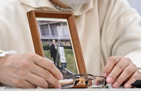 赤木俊夫さんの写真と眼鏡を手に記者会見する妻の雅子さん＝２月、大阪市