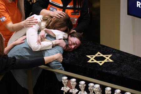 銃乱射事件の犠牲者の葬儀で悲しむ遺族ら＝１７日、シドニー（ゲッティ＝共同）