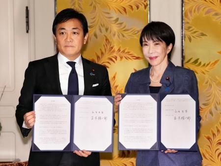 国会内で会談し「年収の壁」引き上げを巡る合意書を手にする高市首相（右）と国民民主党の玉木代表＝１８日午後