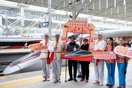 中国陝西省で新たに開業した高速鉄道の延安駅で記念撮影する乗客ら＝２６日（新華社＝共同）
