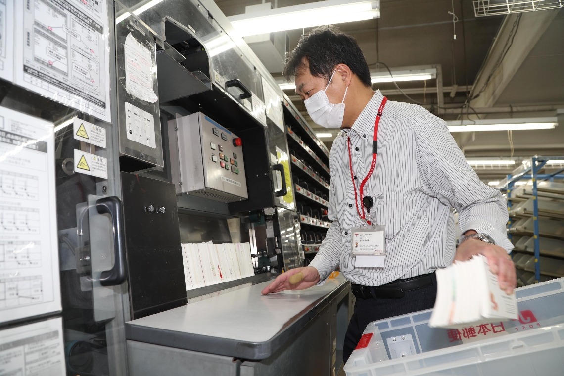 郵便局に集められた年賀状を仕分ける従業員＝大分市府内町の大分中央郵便局