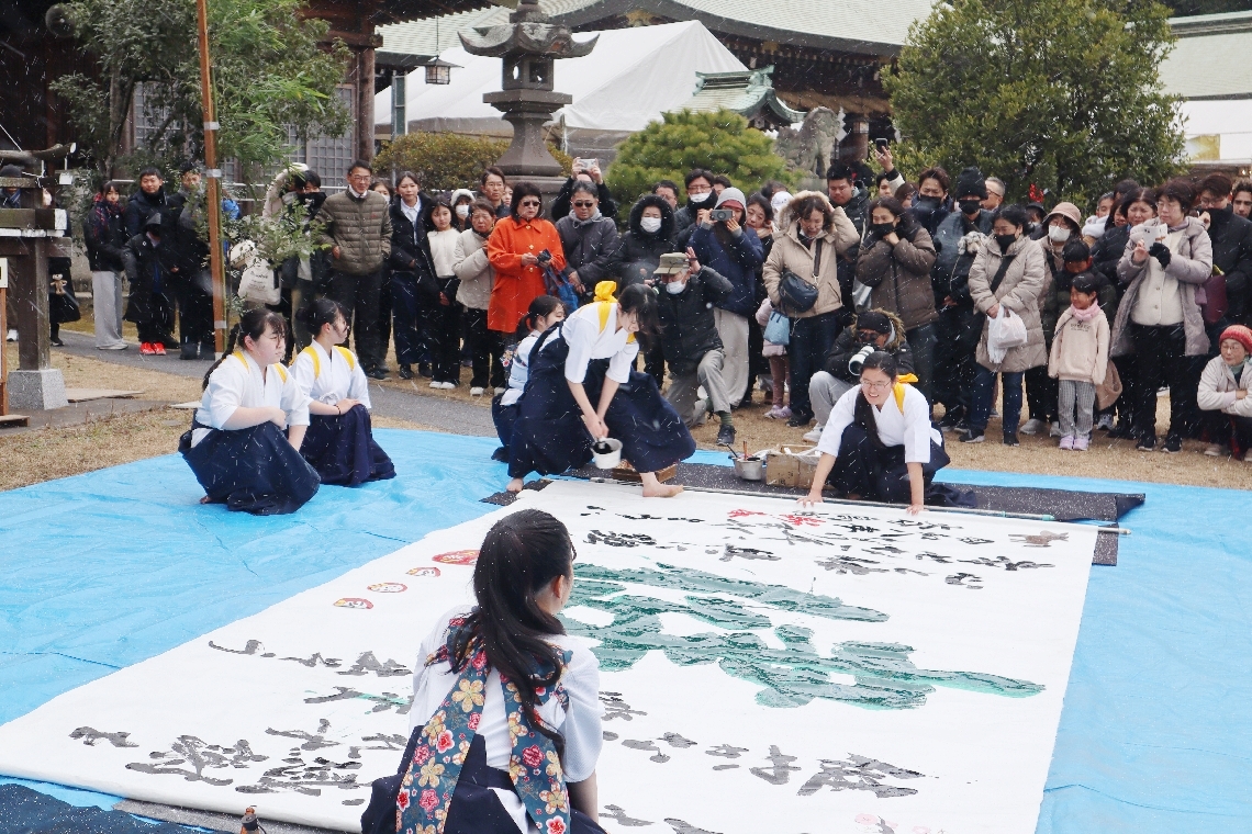 雪が舞う中、書き初めを披露する大分高書道部のメンバー