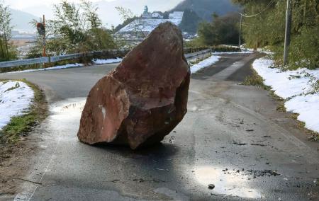 地震の影響で道路に落下した石＝７日午前８時５７分、鳥取県伯耆町