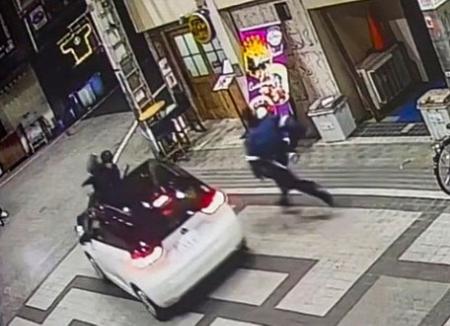 防犯カメラが捉えた、警察官をボンネットに乗せたまま走行する乗用車の映像＝７日午後、大阪府岸和田市（近隣関係者提供）