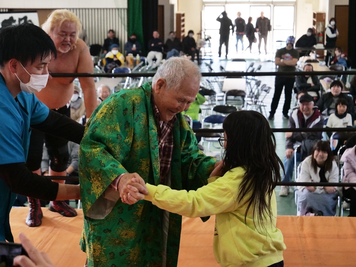 リングに上がり、プロレスを楽しむ子どもと高齢者