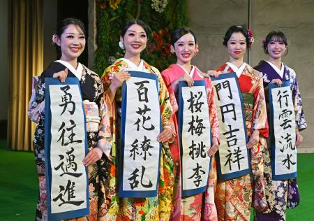 福島県いわき市の温泉施設スパリゾートハワイアンズで、振り袖姿で書き初めを披露する（左から）ＭＯＭＯＫＡさん、ＭＩＭＩさんら２０歳になるフラガール＝１０日午前