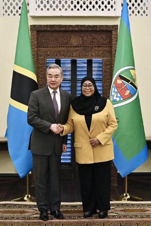 握手する中国の王毅外相（左）とタンザニアのサミア大統領＝１０日、ダルエスサラーム（中国外務省のホームページから、共同）