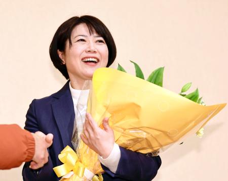 前橋市長選で再選を決め、花束を手にする小川晶氏＝１２日夜、前橋市