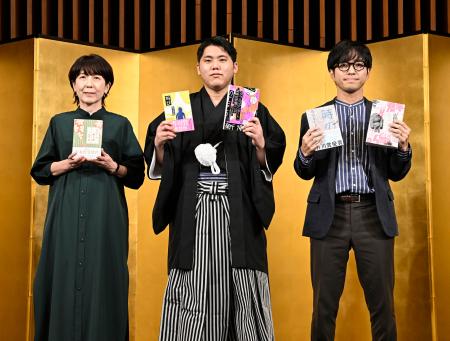 受賞作を手に写真に納まる（左から）直木賞に決まった嶋津輝さん、芥川賞に決まった畠山丑雄さん、鳥山まことさん＝１４日午後、東京都内
