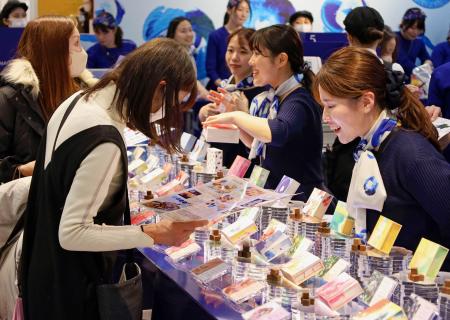 バレンタイン催事「アムール・デュ・ショコラ」の先行販売で品定めをする買い物客（左）＝１５日午後、名古屋市のジェイアール名古屋高島屋