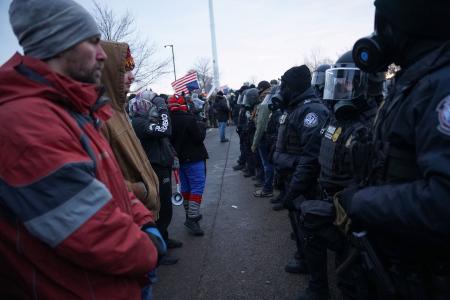 治安当局の職員らと向かい合うデモ隊＝１７日、米ミネソタ州ミネアポリス（ロイター＝共同）