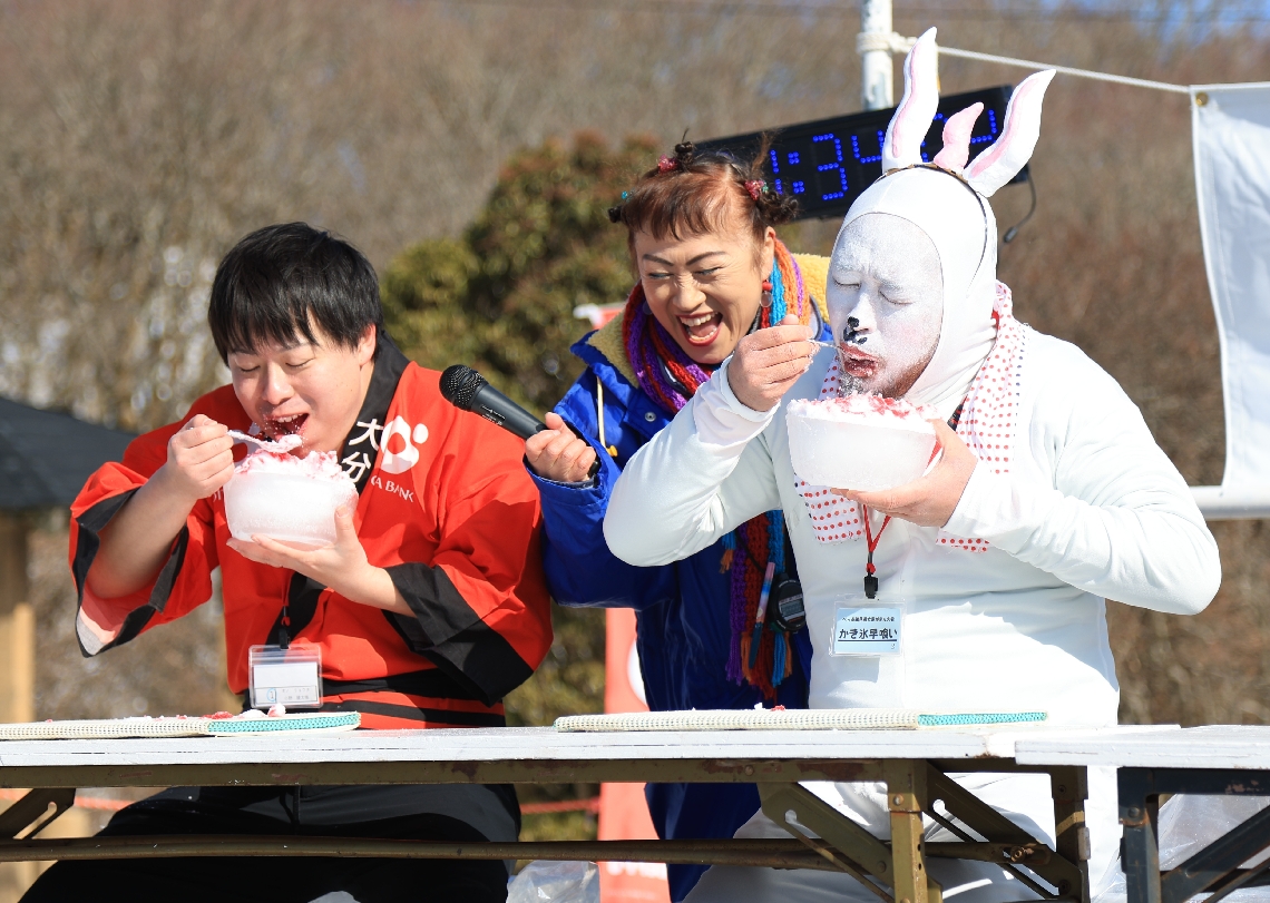 氷の器に盛られたかき氷の早食いに挑戦する参加者ら