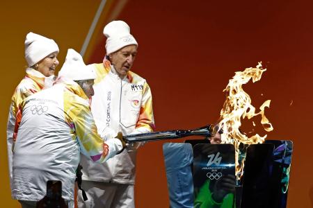 コルティナダンペッツォで行われたミラノ・コルティナ冬季五輪の聖火リレーに参加したランナーのマヌエラ・アンジェリさん（左）ら＝２６日（共同）