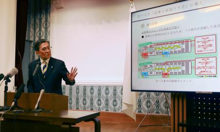 記者会見で市バスの乗降口変更について説明する京都市の松井孝治市長＝２９日午後、京都市役所