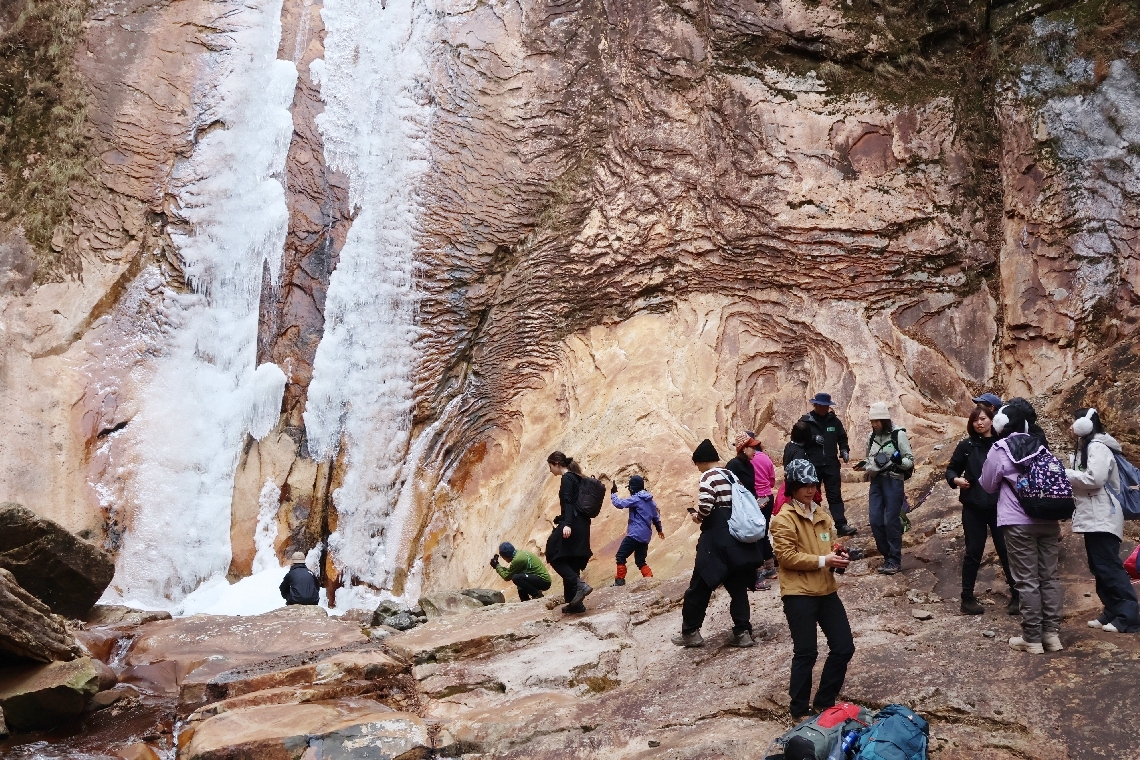 凍った滝の前で思い思いに楽しむ参加者