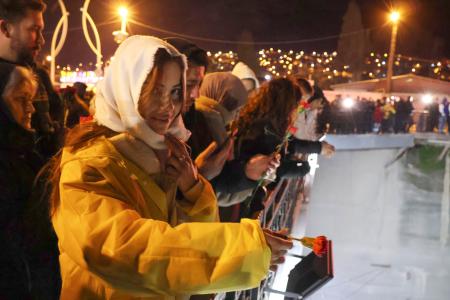 ６日、トルコ・アンタキヤ中心部で、献花する女性ら（共同）