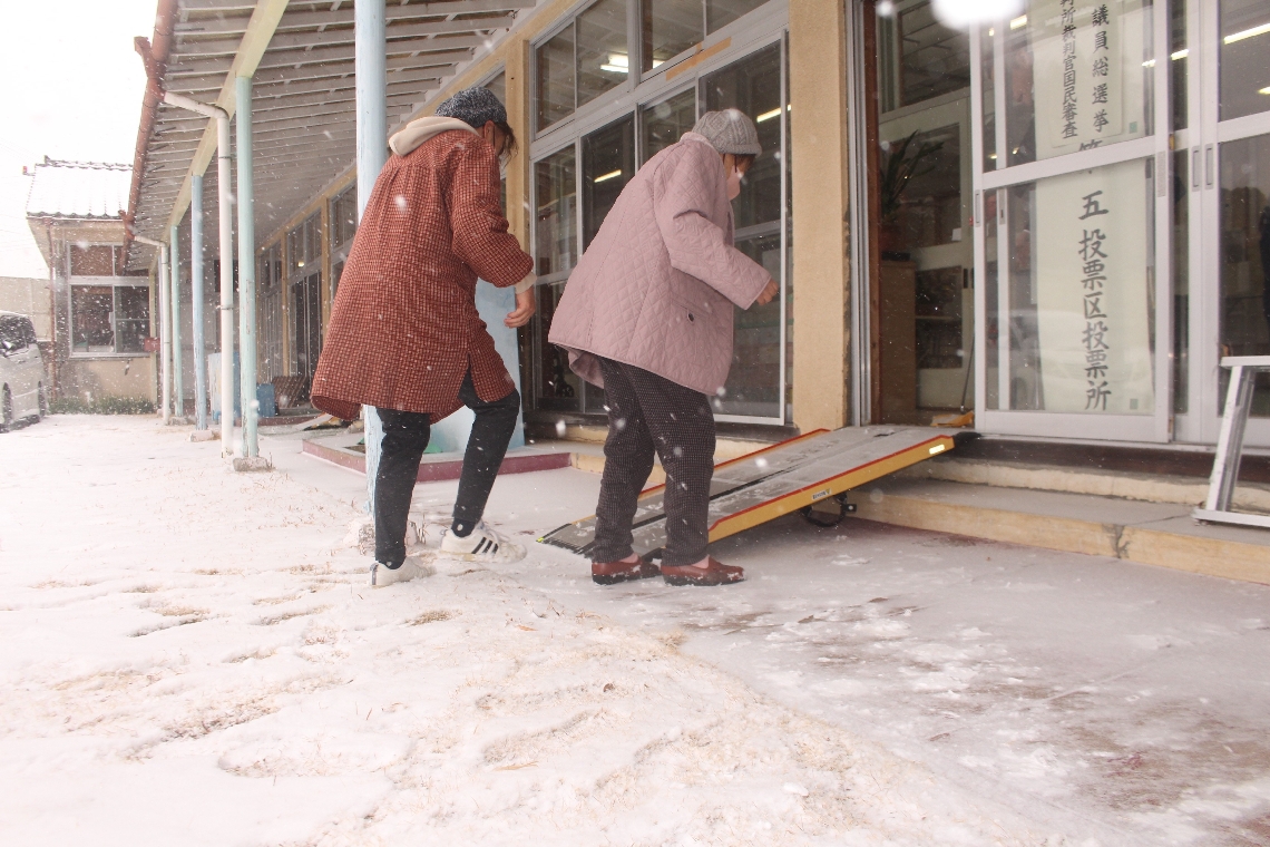 雪が降り積もる中、投票所に足を運んだ有権者＝８日午前８時４２分、竹田市米納の市双城高齢者コミュニティセンター