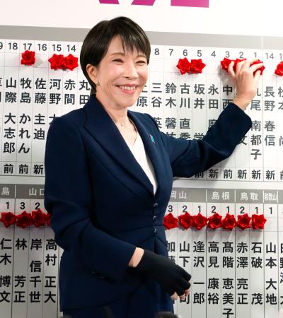 当確者の名前にバラを付ける自民党総裁の高市首相＝８日午後９時４２分、東京・永田町の党本部
