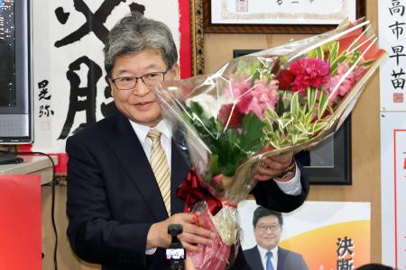 東京２４区で当選を決め、花束を手にする自民党の萩生田光一氏＝８日夜、東京都八王子市