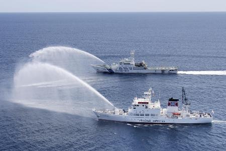 違法操業する外国漁船を想定して放水訓練をする海上保安庁（奥）と水産庁の船＝２０２３年、第９管区海上保安本部提供