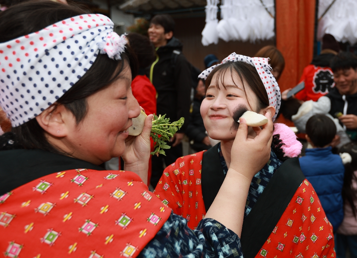笑顔で墨を塗り合う参加者