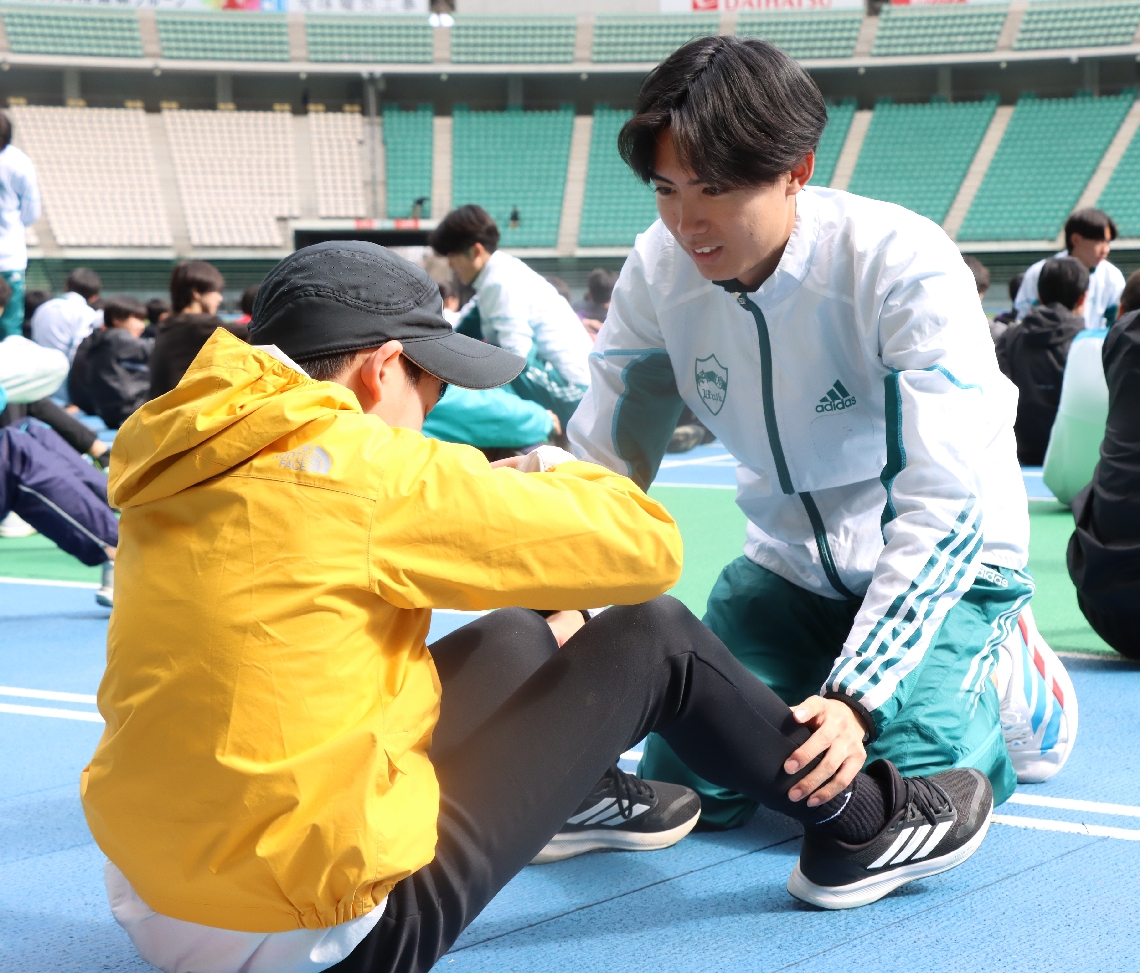 股関節の動かし方を教える青山学院大の佐藤（右）