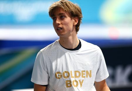 スピードスケート男子１万メートルで金メダルを獲得し「ゴールデン・ボーイ」と書かれたＴシャツ姿を披露したメトジェイ・イレク＝１３日、ミラノ（ロイター＝共同）