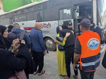 ８日、ガザ南部ハンユニスで検問所への出発を前に別れのあいさつをする人たち（共同）