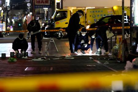 現場付近を調べる大阪府警の捜査員＝１５日午前３時２０分、大阪市中央区