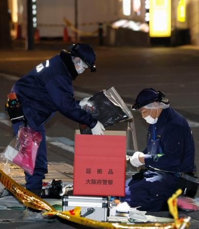 ３人が刺される事件があった現場付近を調べる警察官＝１５日午前２時３４分、大阪市中央区