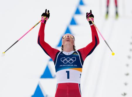 男子５０キロクラシカル　両手を挙げゴールするノルウェーのヨハンネスヘスフロト・クレボ。全６種目制覇を達成した＝テーゼロ（共同）