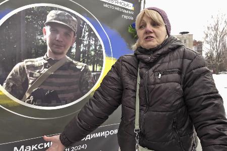 息子の遺影の前で話すナタリア・ネフョードワさん。ロシアのウクライナ侵攻開始から２４日で４年となった＝２３日、ウクライナ・スラビャンスク（共同）