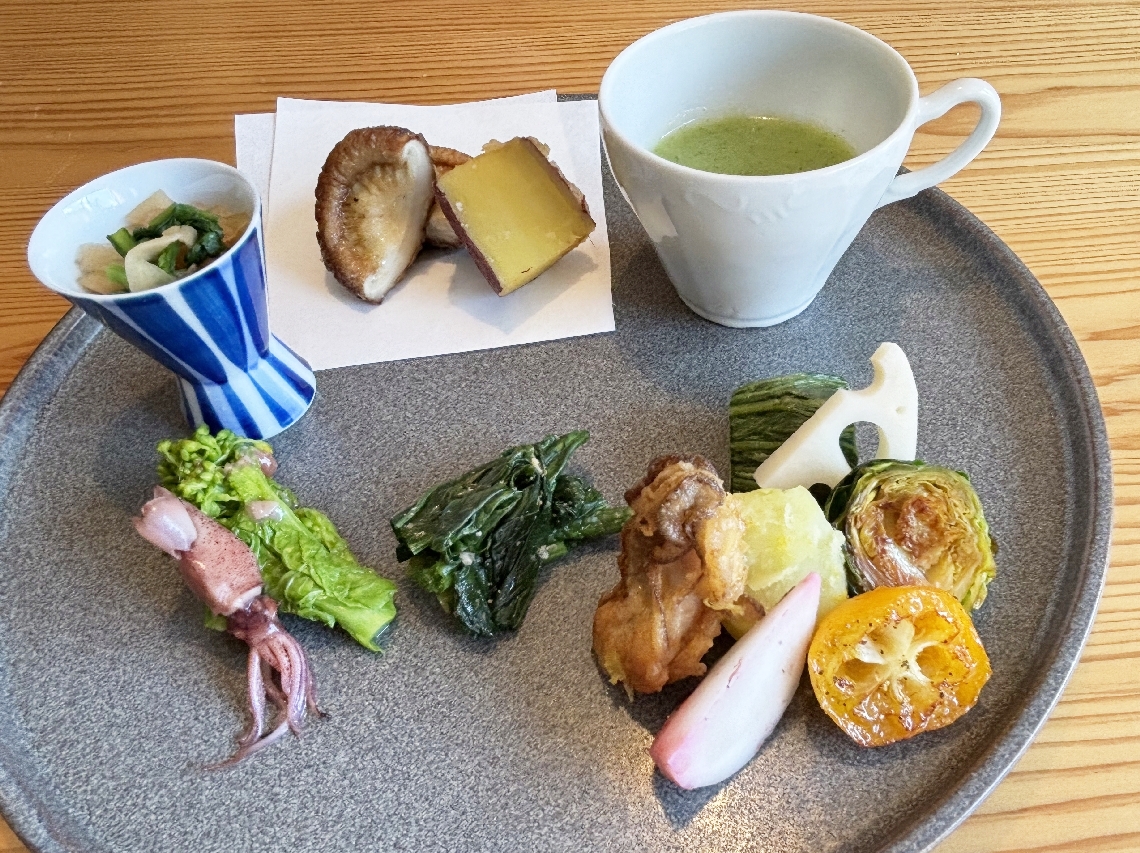 天ぷらやおひたし、スープなどが並ぶ盛り合わせ