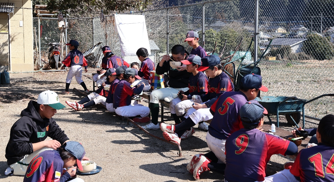 豚汁やおにぎりを食べる由布高野球部と挾間ドリームズの選手