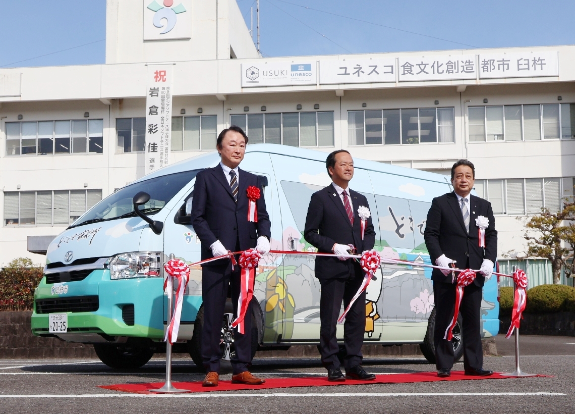 「どこでも市役所」の車両の出発式でテープカットをする西岡隆市長（中央）ら関係者＝臼杵市役所
