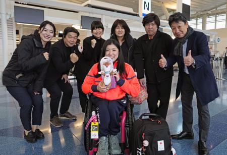 出発前に関係者らと笑顔で記念写真に納まるパラアルペンスキー女子の村岡桃佳（中央）＝２８日、羽田空港