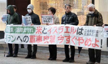 イラン攻撃に対する抗議活動で、横断幕を掲げる人たち＝６日午後、広島市中区