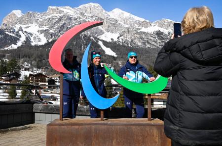 パラリンピックのシンボルマーク「スリーアギトス」と記念撮影する人たち＝６日、イタリア・コルティナダンペッツォ（共同）