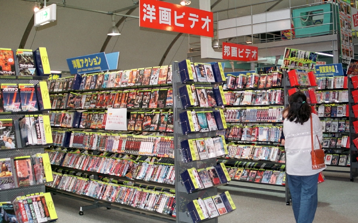 ビデオカセットが並ぶかつてのレンタルビデオ店の店頭