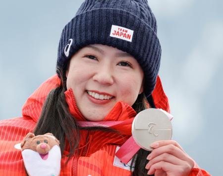 ミラノ・コルティナ冬季パラリンピックのアルペンスキー女子スーパー大回転座位の表彰式で、銀メダルを手に笑顔を見せる村岡桃佳＝９日、イタリア・コルティナダンペッツォ（共同）
