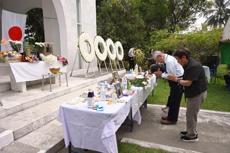 １１日、ミャンマー最大都市ヤンゴンの日本人墓地で実施された戦没者追悼式で手を合わせる遺児ら（共同）