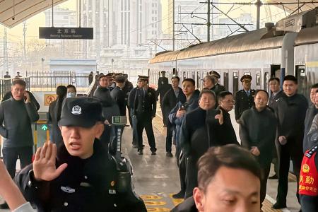 北京駅で出発を待つ平壌行きの旅客列車と警戒する治安当局者＝１２日（共同）