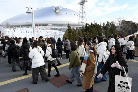 アイドルグループ「嵐」の公演が行われる札幌市の大和ハウスプレミストドームに向かう人たち＝１３日午後
