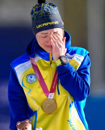バイアスロン女子７・５キロ立位で獲得した金メダルを胸に、涙ぐむウクライナのオレクサンドラ・コノノワ＝７日、イタリア・テーゼロ（共同）